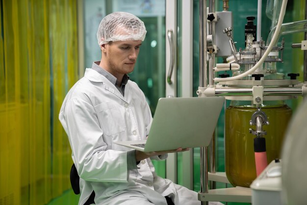 Foto científico boticario que registra datos del extractor de aceite de cbd en laboratorio