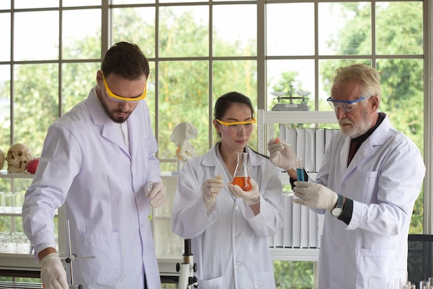 Científico con colegas examinando productos químicos en el laboratorio