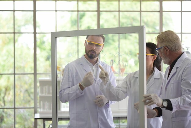 Foto científico discutiendo la fórmula mientras está de pie en el laboratorio