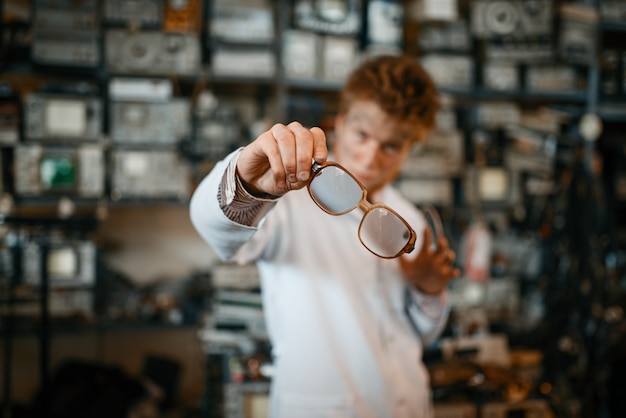 Científico extraño mira a través de las gafas en el laboratorio. Equipo de laboratorio, taller de ingeniería