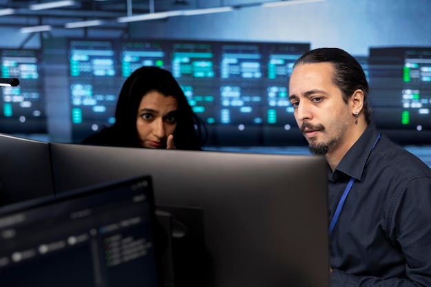 Científico informático y compañero de trabajo salvaguardando el hardware del centro de datos