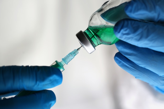 Científico con jeringa de vacuna de drogas verde