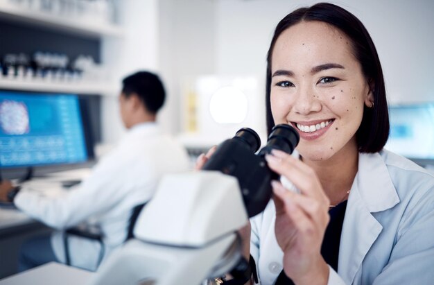 Científico de laboratorio cara o microscopio en investigación médica estudio de medicina sanitaria o farmacia médica japonesa Sonrisa de retrato o mujer asiática feliz con equipo científico en ingeniería futura