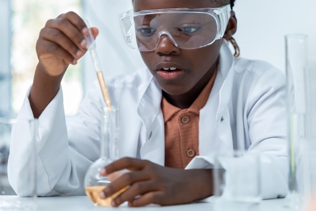 Científico en el laboratorio con gafas sosteniendo un frasco químico analizando una muestra en la investigación