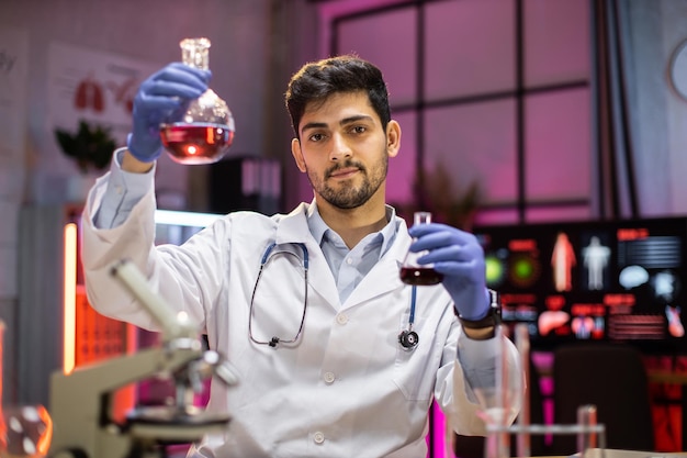 Foto científico masculino indio trabajando con matraz analizando muestras bioquímicas