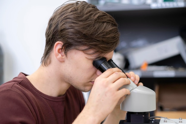 científico masculino investiga en laboratorio con microscopio b