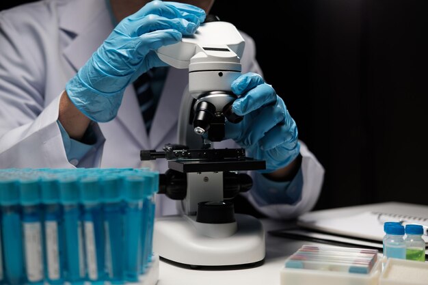 Foto científico médico examinando muestras usando un microscopio en un laboratorio moderno