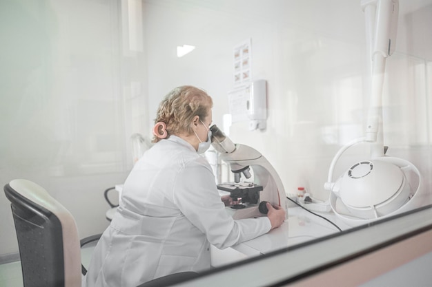 Un científico mira a través de un microscopio en un laboratorio.