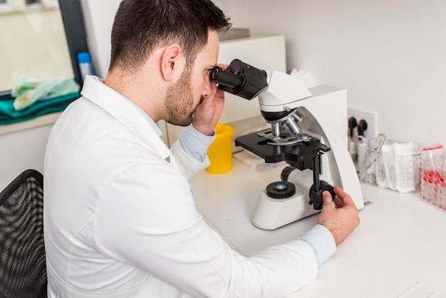 Científico mirando a través de un microscopio en un laboratorio en el hospital