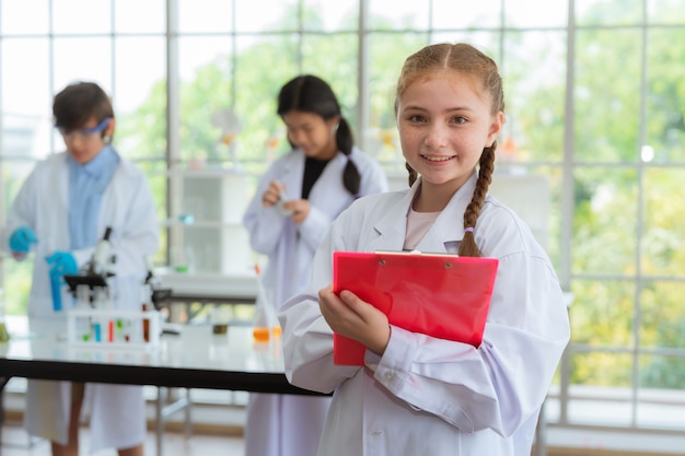 Científico de la muchacha que sonríe en sitio del laboratorio en escuela Concepto de la ciencia y de la educación.