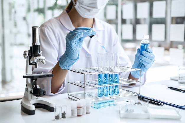 Foto científico o médico en bata de laboratorio con tubo de ensayo