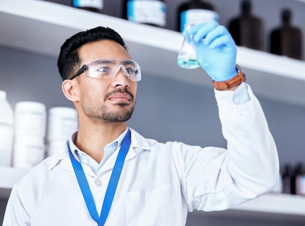 Foto científico químico azul en vaso de precipitados y hombre en investigación médica de laboratorio y experimento científico con análisis solución líquida de médico masculino y química con estudio científico salud y biotecnología