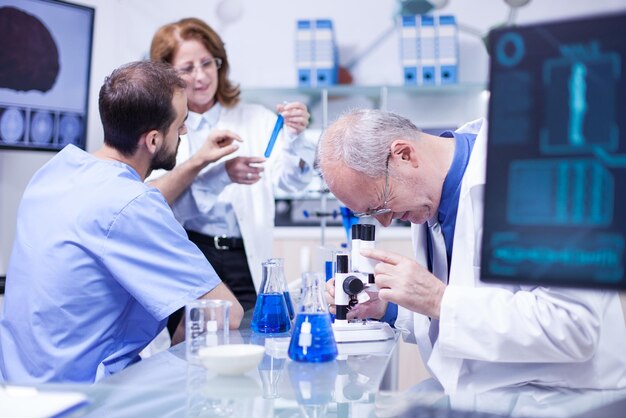 Científico senior usando un microscopio en un laboratorio de hospital para investigación. Equipo de laboratorio moderno.