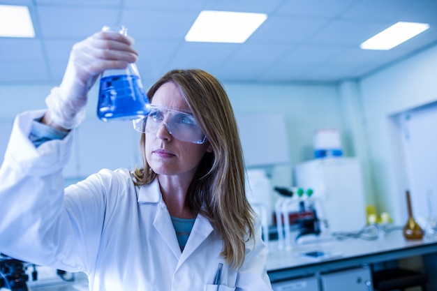 Foto científico sosteniendo vaso de precipitados de sustancia química