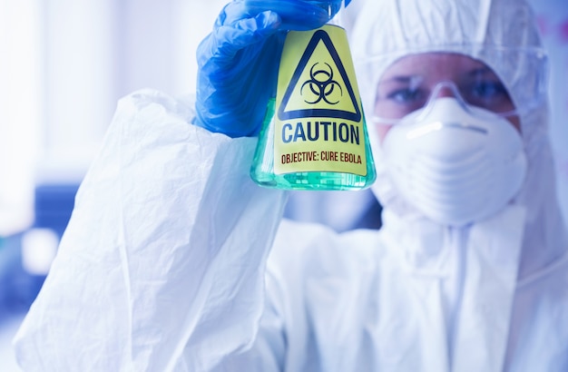 Foto científico en traje protector con vaso de precipitados