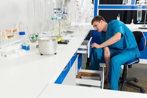 Científico en uniforme está buscando algo en unos casos en un laboratorio. Concepto de salud y biotecnología