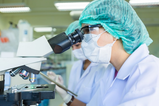 Científico utilizando un microscopio en un laboratorio