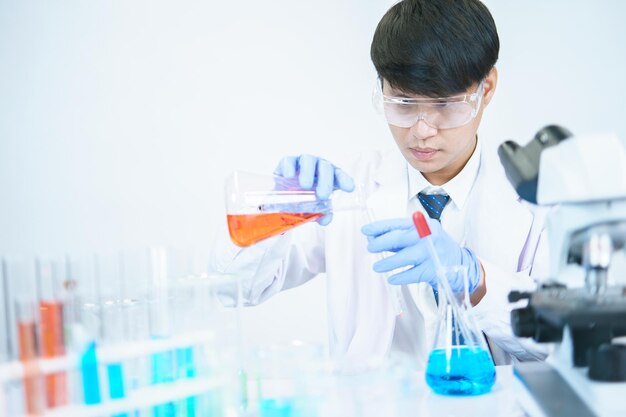 Los científicos asiáticos están estudiando seriamente la composición química en el laboratorio. Especializados en biotecnología joven. Uso de equipos de microscopio avanzados.