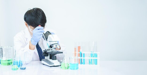 Los científicos asiáticos están estudiando seriamente la composición química en el laboratorio. Especializados en biotecnología joven. Uso de equipos de microscopio avanzados.