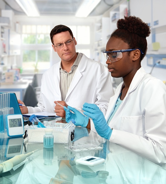 Científicos, hombres caucásicos y mujeres africanas, trabajan en el laboratorio.