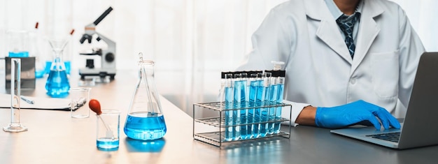 Los científicos llevan a cabo experimentos químicos e investigaciones en laboratorios médicos como pioneros en el desarrollo de nuevas vacunas, fármacos o antibióticos y estudian los resultados de las pruebas en la computadora portátil Neoteric