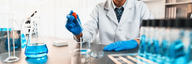 Foto los científicos realizan un experimento químico en un laboratorio médico y colocan cuidadosamente la cantidad precisa de líquido de la pipeta en el tubo de ensayo para el desarrollo de antibióticos o medicamentos para vacunas neoteric