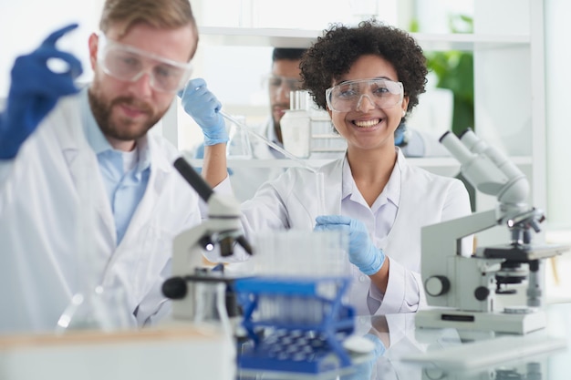 Científicos sonrientes mirando a la cámara con los brazos cruzados en el laboratorio