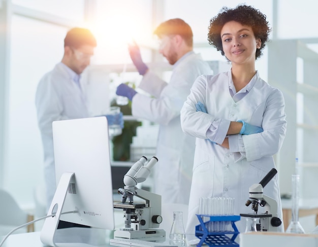 Científicos sonrientes mirando a la cámara con los brazos cruzados en el laboratorio