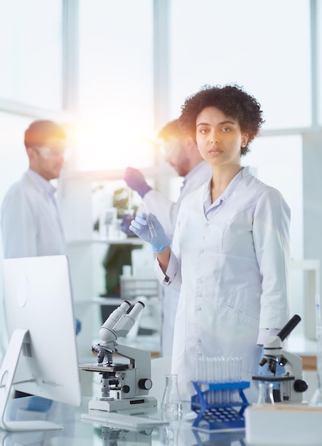 Científicos sonrientes mirando a la cámara con los brazos cruzados en el laboratorio