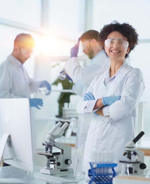 Foto científicos sonrientes mirando a la cámara con los brazos cruzados en el laboratorio