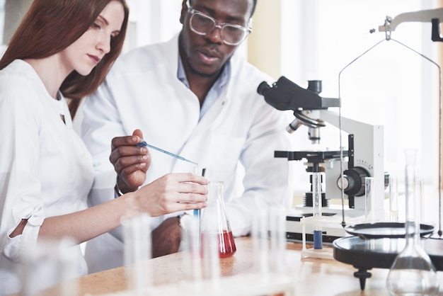 Los científicos trabajan estrechamente con el microscopio en el laboratorio realizando experimentos y análisis.