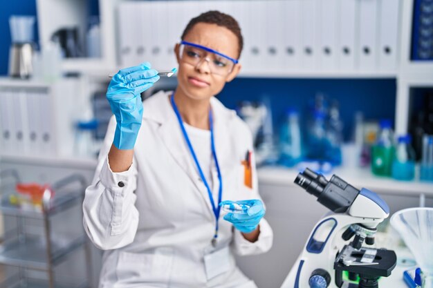 Cientista afro-americana segurando pílula no laboratório