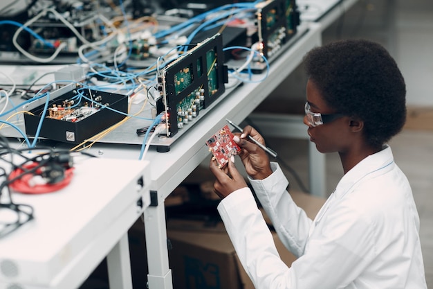 Cientista afro-americana trabalhando em laboratório com instrumentos eletrônicos