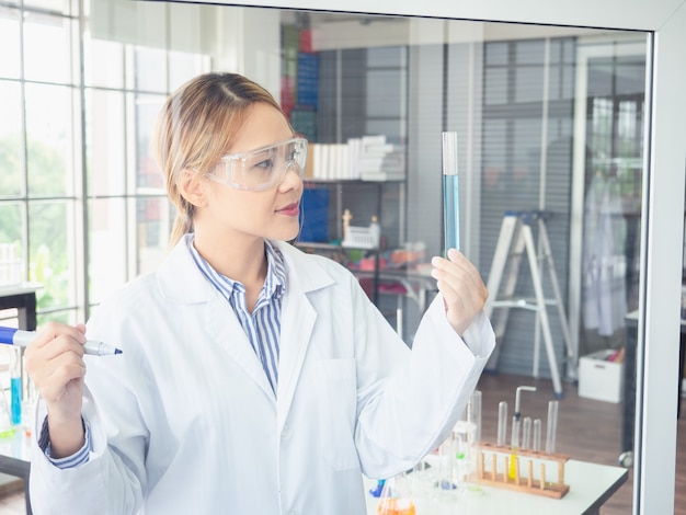 Cientista asiática escreve uma fórmula em uma placa de vidro