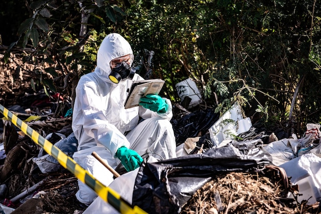 Foto cientista asiático usa traje de proteção química, verifica o perigo, trabalho químico em zona perigosa, coleta de amostras em caso de investigação do vírus corona surgido da china