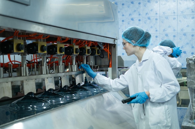 Cientista de casaco branco e chapéu azul trabalhando na máquina de controle da linha de produção.