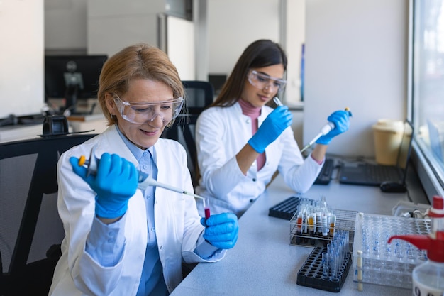 Cientista de pesquisa feminina usa micro pipeta enquanto trabalha com tubos de ensaio pessoas em laboratório farmacêutico inovador com equipamentos médicos modernos para pesquisa genética