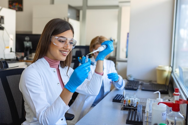 Cientista de pesquisa médica feminina analisa amostras biológicas antes de analisá-las sob o microscópio digital no laboratório de ciências aplicadas Engenheiro de laboratório em jaleco branco trabalhando em vacinas e remédios