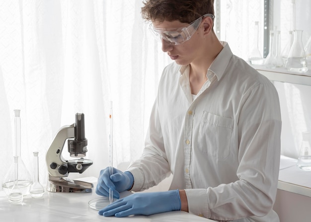 Foto cientista de tiro médio trabalhando em laboratório