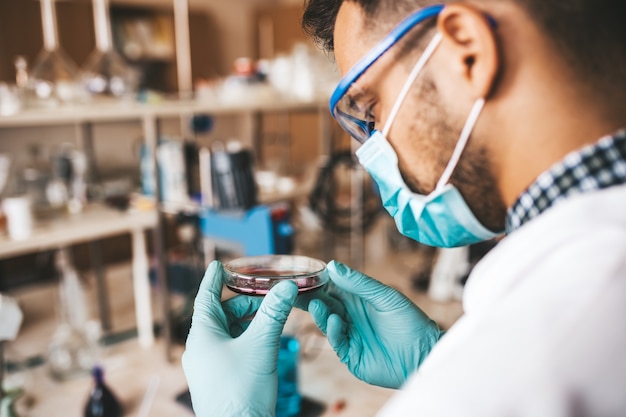 Cientista e pesquisador de meia-idade trabalha em laboratório químico.