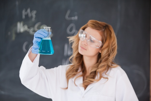Foto cientista feminina olhando um frasco