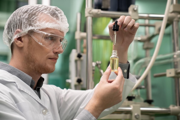 Cientista ou boticário extrai óleo de cânhamo CBD para fins medicinais em laboratório