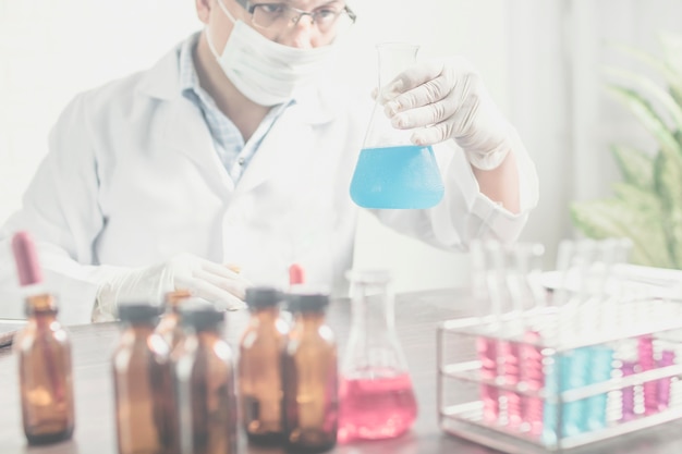 Cientista ou pesquisador segurando balão no laboratório de Ciências.