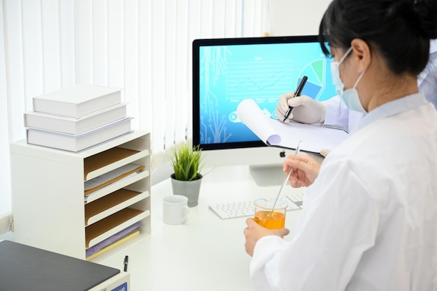 Cientista ou química asiática concentrada trabalhando com sua equipe no laboratório