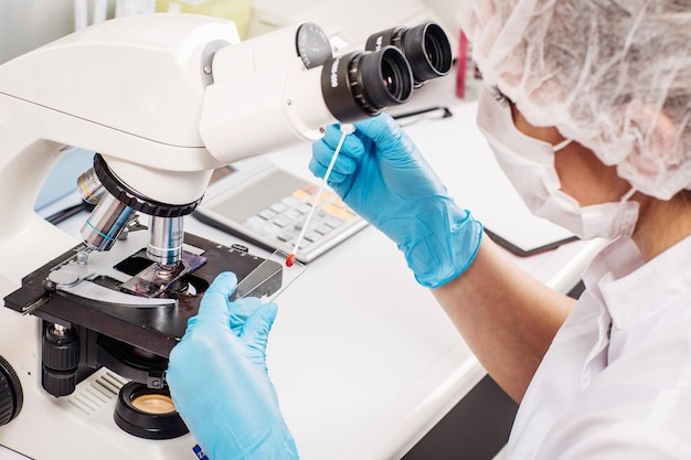 Cientista profissional fazendo pesquisa com microscópio em laboratório clínico xA