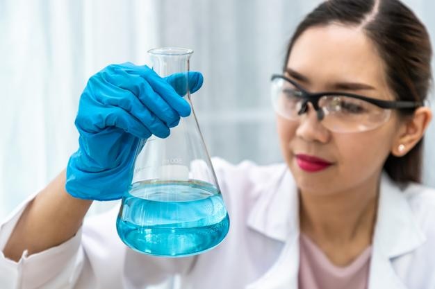 Cientista químico mulher segurando frascos e realizando experimentos em laboratório com o conceito de ciência de equipamentos