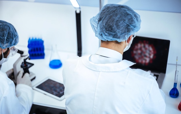 Foto cientista retrovisor sentado em uma mesa no laboratório