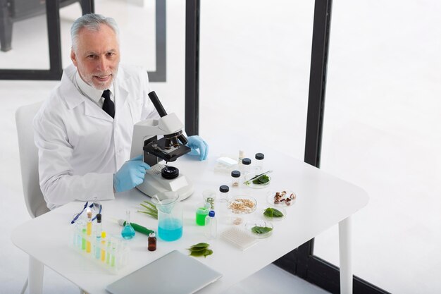 Foto cientista trabalhando com microscópio de alto ângulo