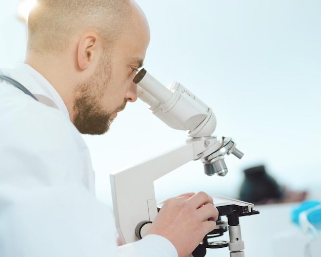 Cientista usando um microscópio na vista lateral do laboratório