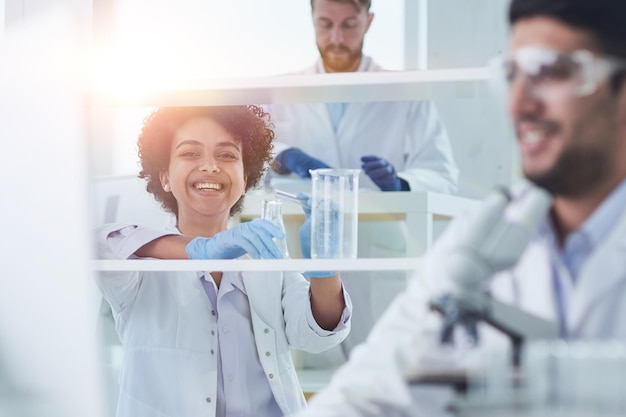 Cientistas sorridentes olhando para os braços da câmera cruzados em laboratório